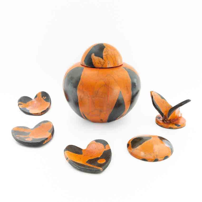 Oranje raku urn met bijpassende harten urn_urnen_keramiek_keramische_rtaku_oranje_vlinder_deksel_waxinelichtje_hartje_bol_kopen_bijzondere_unieke_handgemaakt_op_maat_urnmaatwerk_dezeeltinbeeld